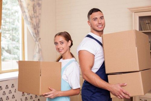 Professional movers handling bulky furniture in a narrow Soho staircase