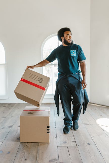 Two removal specialists from Removal Companies Soho are preparing to load furniture and packaging materials from a storefront on a street with the shop name 'Guangzhou', which has Chinese characters a